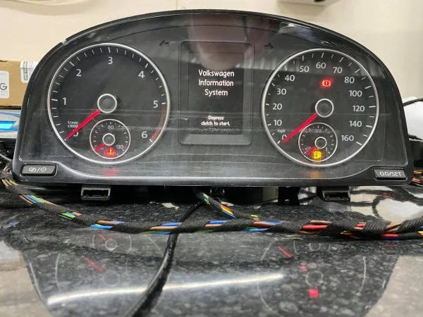 VW Caddy Highline instrument cluster connected on a bench with Volkswagen Information System on its white display