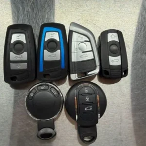 BMW remote keys in several casing designs on a workshop surface