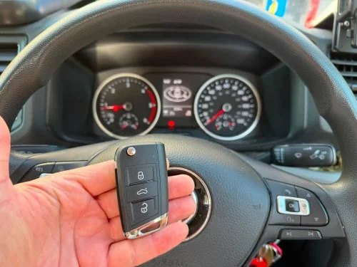 Volkswagen remote key held in front of the VW Crafter steering wheel and instrument cluster